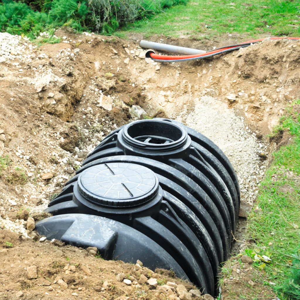 An uncovered septic tank placed in a large ditch.